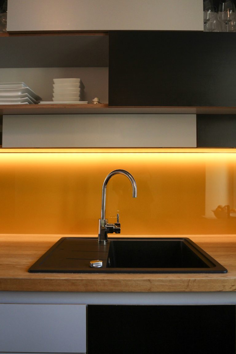 Black sink with yellow backdrop